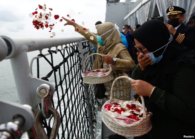 Anggota keluarga penumpang Sriwijaya Air penerbangan SJ 182 yang jatuh ke laut menaburkan bunga dari dek kapal TNI Angkatan Laut KRI Semarang saat mengunjungi lokasi jatuhnya pesawat untuk memberikan penghormatan, di laut, 22 Januari 2021.