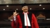 FILE - Indonesia's top judge Akil Mochtar poses for photos during a swearing-in ceremony in Jakarta. Mochtar on Indonesia's Constitutional Court has been arrested on suspicion of bribery in the country's laest high-profile graft scandal.