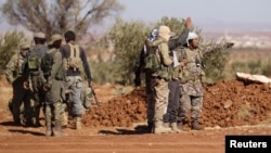 FILE - Rebel fighters gather during their advance towards the Islamic State-held city of al-Bab, northern Syria Oct. 26, 2016.