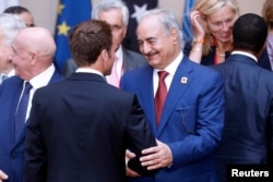 FILE - Khalifa Haftar, the military commander who dominates eastern Libya, shakes hands with French President Emmanuel Macron in Paris, France, May 29, 2018.