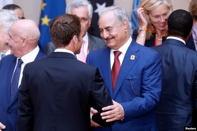 FILE - Khalifa Haftar, the military commander who dominates eastern Libya, shakes hands with French President Emmanuel Macron in Paris, France, May 29, 2018.
