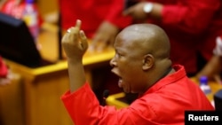 FILE - Julius Malema, leader of the Economic Freedom Fighters (EFF) party, raises objections before being evicted from Parliament during President Jacob Zuma's question and answer session in Cape Town, South Africa, May 17, 2016. 