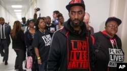 Flint residents and supporters wear shirts that reads "Flint Lives Matter" as they wait outside the room where Michigan Gov. Rick Snyder and EPA Administrator Gina McCarthy testify before a House Oversight and Government Reform Committee hearing in Washington, March 17, 2016, to look into the circumstances surrounding high levels of lead found in many residents' tap water in Flint, Michigan.