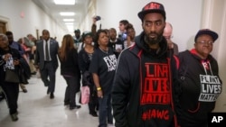 Flint residents and supporters wear shirts that reads "Flint Lives Matter" as they wait outside the room where Michigan Gov. Rick Snyder and EPA Administrator Gina McCarthy testify before a House Oversight and Government Reform Committee hearing in Washington, D.C., March 17, 2016. (AP Photo/Andrew Harnik)