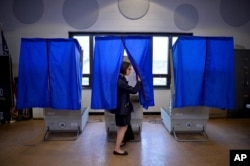 FILE - FILE - A voter leaves a voting booth after casting her ballot in the Pennsylvania primary, at a polling place in Philadelphia, Pennsylvania, April 26, 2016.