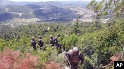 A picture taken on a tour organized by the Syrian Red Crescent shows Syrian soldiers deploying along the Syrian-Turkish border near the village of Khirbet al-Joz in the northern province of Idlib, June 29, 2011