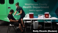 Nurse Elizabeth Head gets ready to give Andrew Seay his COVID-19 vaccine at Grace Fellowship Church in Ypsilanti, Michigan, U.S., August 7, 2021. (REUTERS/Emily Elconin)