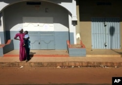 A woman looks down an empty street in Banjul, in Gambia, Jan. 18, 2017.