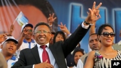 FILE - Hery Rajaonarimampianina (L) acknowledges the crowd with his wife Lalao (R) at anelection campaign rally in Antananarivo, Madagascar, in October 2013.