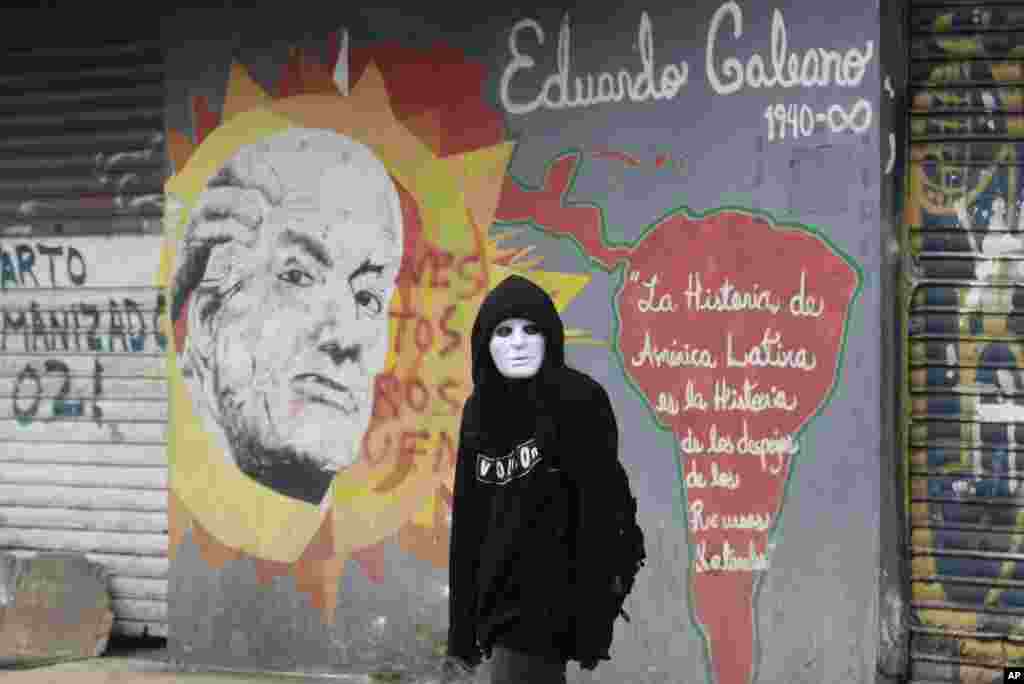 Un estudiante universitario camina junto a un mural del fallecido periodista uruguayo Eduardo Galeano, con una cita suya, cerca de la Asamblea Nacional. 