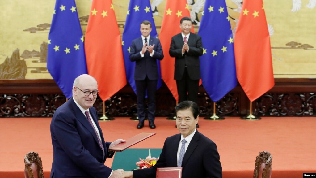 2019年11月6日，法国总统马克龙与中国国家主席习近平见证欧盟农业和农业发展事务专员菲尔·霍甘与中国商务部长钟山在北京人大会堂签署协议。（路透社）(photo:VOA)