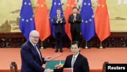 2019年11月6日，法国总统马克龙与中国国家主席习近平见证欧盟农业和农业发展事务专员菲尔·霍甘与中国商务部长钟山在北京人大会堂签署协议。（路透社）