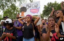 Police and protesters face off in Baton Rouge, La, last year over the shooting of a black man by police, followed by a fatal attack on three police officers. (AP Photo/Max Becherer)