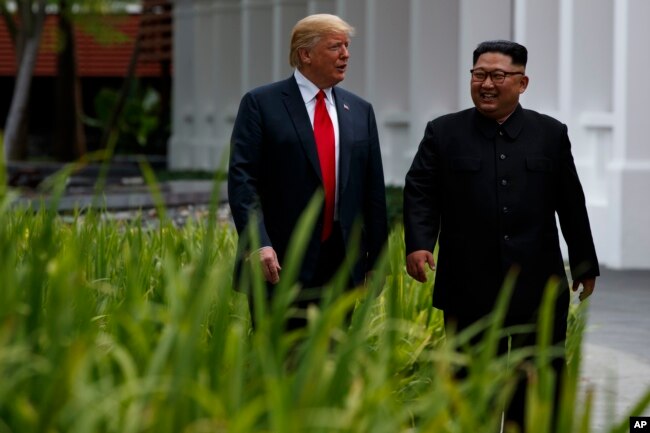 FILE - President Donald Trump walks with North Korean leader Kim Jong Un on Sentosa Island, June 12, 2018, in Singapore.