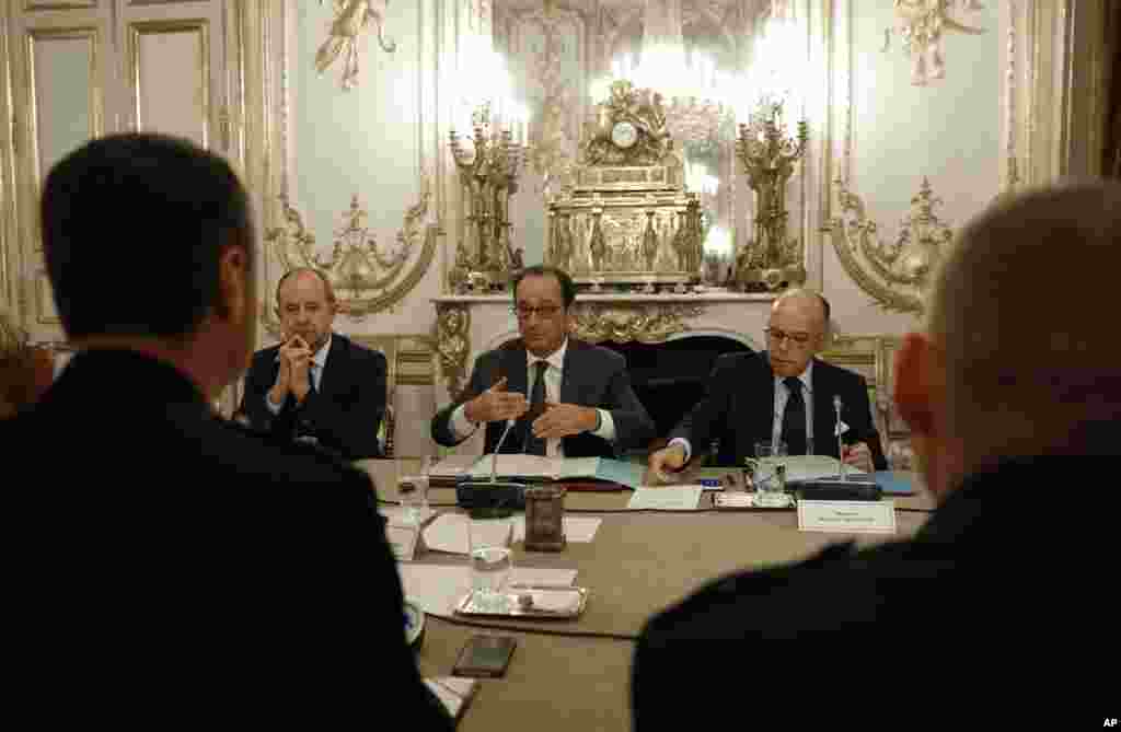French President Francois Hollande, center, Interior Minister Bernard Cazeneuve, right, and Justice Minister Jean-Jacques Urvoas speak with representatives of the French Gendarmerie during a meeting at the Elysee Palace in Paris, Oct. 26, 2016.