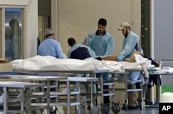 Medical personnel examine a body at the Orlando Medical Examiner's Office, June 12, 2016, in Orlando, Florida. A gunman opened fire inside a crowded gay nightclub early Sunday, before being killed in a gunfight with SWAT officers, police said.
