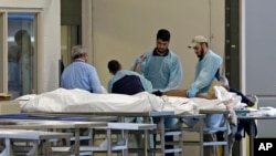 Medical personnel examine a body at the Orlando Medical Examiner's Office, June 12, 2016, in Orlando, Florida, following a shooting that killed 49 people. U.N. High Commissioner for Human Rights Zeid Ra’ad al-Hussein has expressed concern over the high rate of gun violence in the Americas.