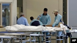 Medical personnel examine a body at the Orlando Medical Examiner's Office, June 12, 2016, in Orlando, Florida. A gunman opened fire inside a crowded gay nightclub early Sunday, before being killed in a gunfight with SWAT officers, police said.