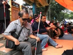 Seorang penyandang disabilitas netra berteduh dalam tenda yang didirikan mahasiswa disabilitas setelah diputus layanan oleh Asrama Wyata Guna, Bandung, Rabu (15/1/20) sore. (VOA/Rio Tuasikal)