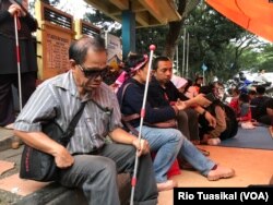 Seorang penyandang disabilitas netra berteduh dalam tenda yang didirikan mahasiswa disabilitas setelah diputus layanan oleh Asrama Wyata Guna, Bandung, Rabu (15/1/20) sore. (VOA/Rio Tuasikal)