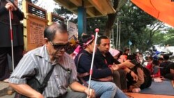 Seorang penyandang disabilitas netra berteduh dalam tenda yang didirikan mahasiswa disabilitas setelah diputus layanan oleh Asrama Wyata Guna, Bandung, Rabu (15/1/20) sore. (VOA/Rio Tuasikal)