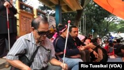 Seorang penyandang disabilitas netra berteduh dalam tenda yang didirikan mahasiswa disabilitas setelah diputus layanan oleh Asrama Wyata Guna, Bandung, Rabu (15/1/20) sore. (VOA/Rio Tuasikal)