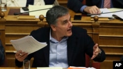 Greece's Finance Minister Euclid Tsakalotos reacts during a parliamentary debate in Athens, Dec. 19, 2017. Greek lawmakers later voted to approve the country's 2018 budget, which includes further austerity measures beyond the official end of Greece's third international bailout next summer. 