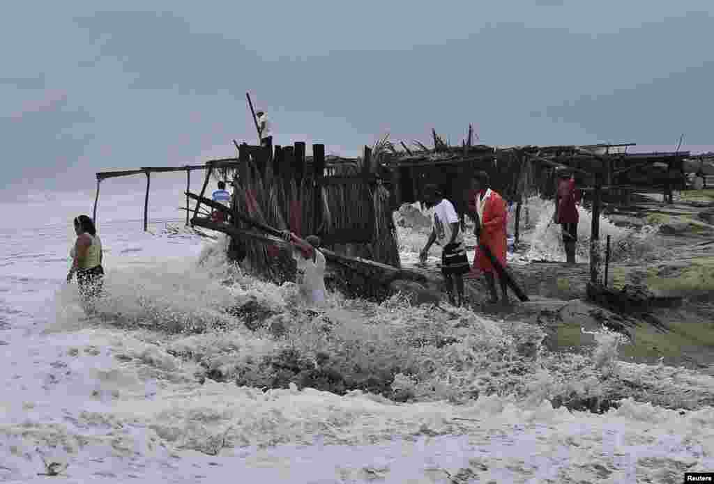 Warga menyelamatkan kayu-kayu setelah ombak besar menyapu tempat peristirahatan di pantai&nbsp;Coyuca de Benitez, pinggiran&nbsp;Acapulco, Meksiko. 