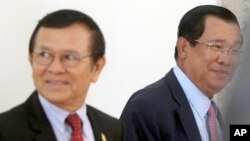 FILE PHOTO - Cambodia's Prime Minister Hun Sen, right, walks with opposition Cambodia Rescue Party Deputy President Kem Sokha, left, during a break at National Assembly in Phnom Penh, Cambodia, Wednesday, Dec. 7, 2016. 