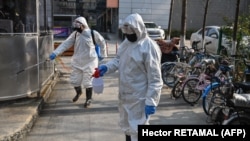 Un equipo de emergencia de salud desinfecta el área en Wuhan, China, donde se presume surgió el coronavirus.
