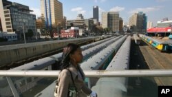 FILE: a Johannesburg resident walks on Mandela Bridge above trains over the railroad tracks in Johannesburg. Taken 6.29.2006
