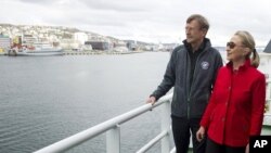 US Secretary of State Hillary Rodham Clinton, right, speaks with Jarle Aarbakke, Rector of the University of Tromso, aboard the Arctic Research Vessel Helmer Hanssen during a boat tour of the coastline with Norway's Minister of Foreign Affairs Jonas Gahr 