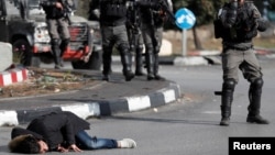Một người đàn ông Palestine nằm trên mặt đất sau khi bị cảnh sát biên phòng Israel bắn gần khu định ngư Do Thái Beit El, gần thành phố Ramallah ở Bờ Tây,ngày 15 tháng 12, 2017.