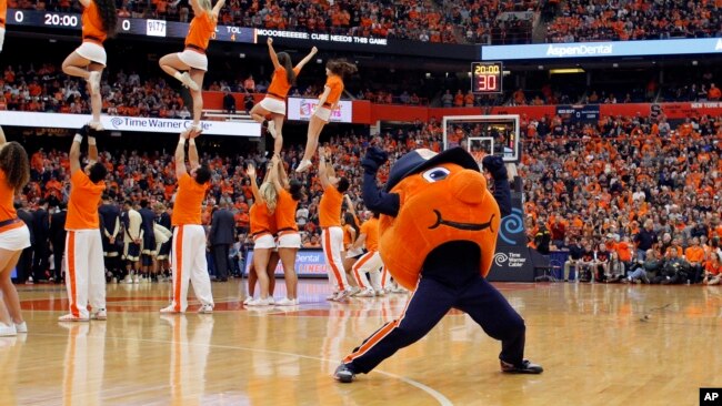 Syracuse University mascot “Otto the Orange” cheers with members of the Syracuse University cheerleading team before an NCAA college basketball game against Pittsburgh in Syracuse, N.Y., Saturday, Feb. 20, 2016. (AP Photo/Nick Lisi)