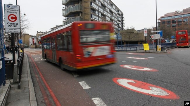 FILE - Traffic signs are seen showing the entrance into London's congestion charge zone for central London, Jan. 4, 2011.