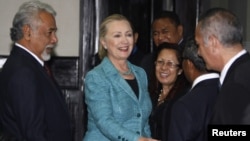 U.S. Secretary of State Hillary Clinton (C) shakes hands with staff members next to East Timor's Prime Minister Xanana Gusmao (L) at the Prime Minister's office in Dili September 6, 2012. 