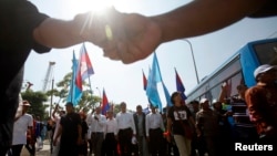 Sam Rainsy (C), leader of the opposition Cambodia National Rescue Party (CNRP), marches during International Human Rights Day in Phnom Penh, Dec. 10, 2013. 
