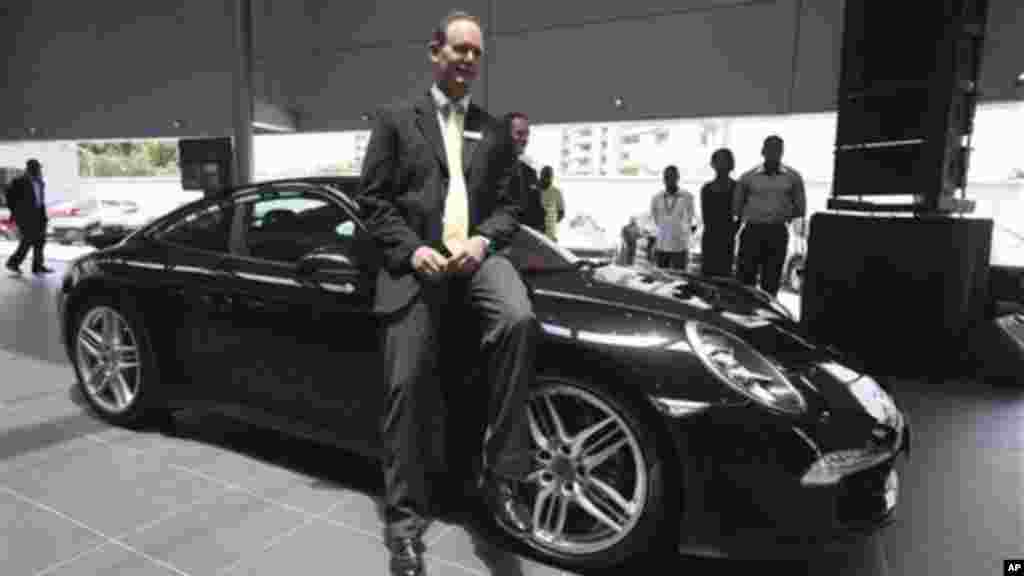 Michael Wagner, the Porsche SA brand manager for Stallion Motors Ltd. of Nigeria, sits on a new Porsche Carrera 911 outside of a showroom for the luxury brand on Victoria Island in Lagos, Nigeria.