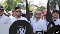 FILE - James Fields, second from left, holds a black shield in Charlottesville, Va., where a white supremacist rally took place, Aug. 12, 2017. Fields was later charged after authorities say he plowed a car into a crowd of people protesting the white nationalist rally. 