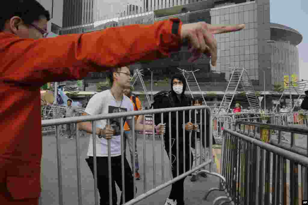 Pro-democracy protesters remove barricades from an occupied area outside government headquarters in Hong Kong's Admiralty district, Nov. 18, 2014. 