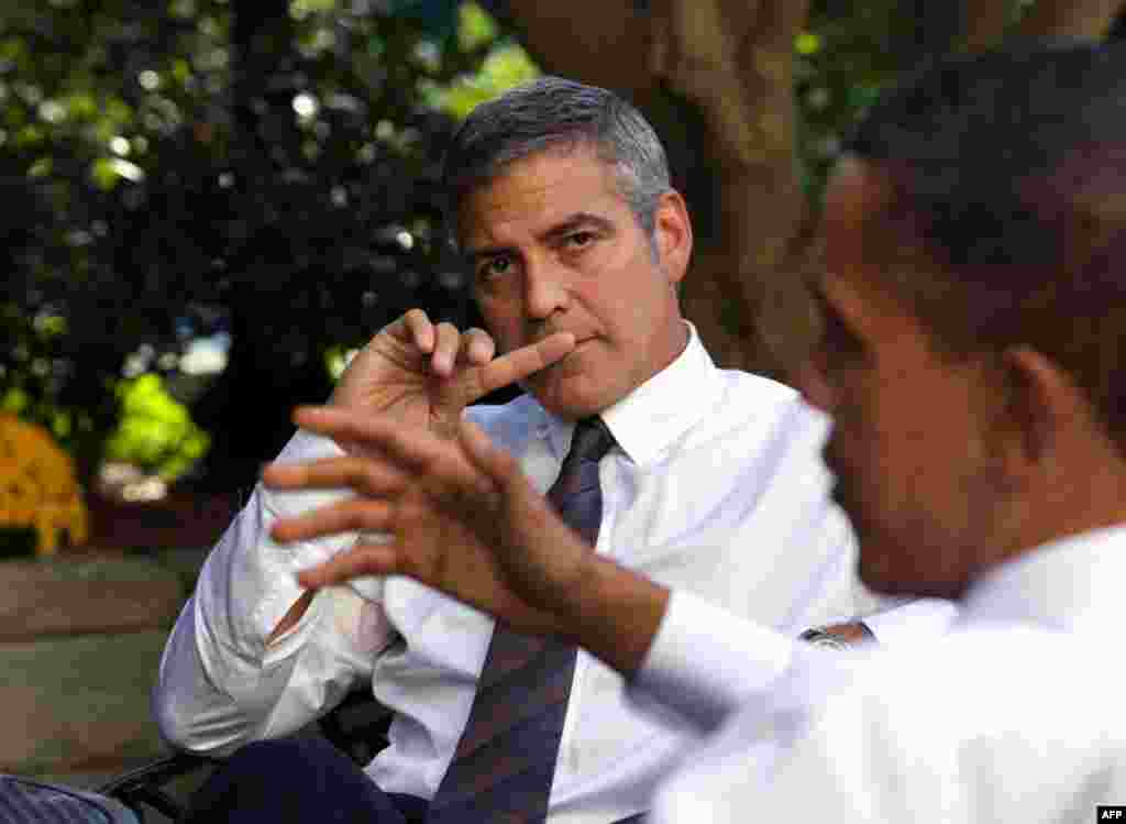 President Barack Obama talks about Sudan with actor George Clooney during a meeting outside the Oval Office, Oct. 12, 2010. (Official White House Photo by Pete Souza) This official White House photograph is being made available only for publication by n