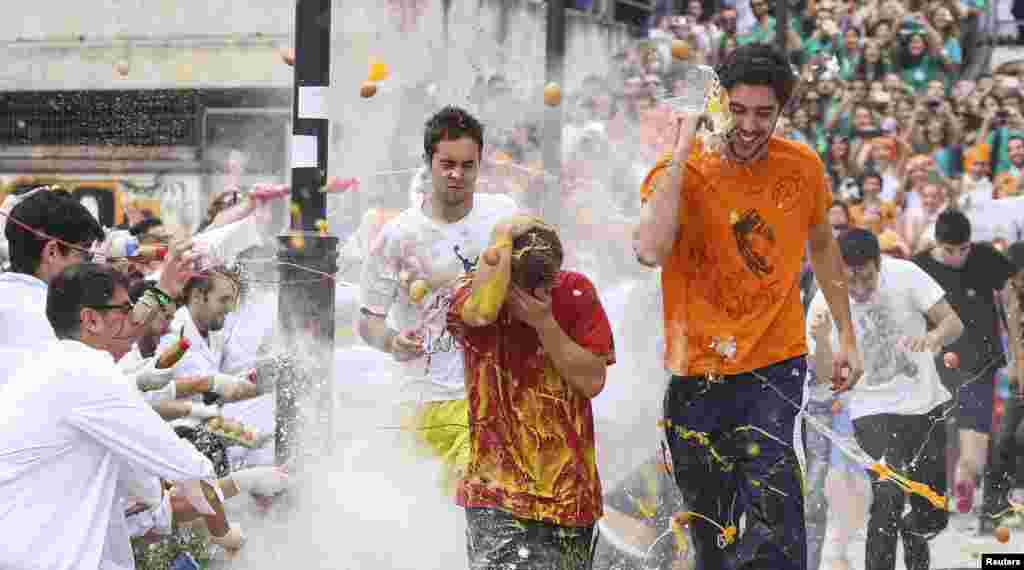 Faculty of medicine first year students run while seniors spray them with different types of sauces, liquids, flour and eggs as part of an annual tradition during a celebration in honor of their patron Saint Lucas at Granada University in Granada, southern Spain.