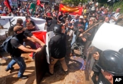 White nationalist demonstrators clash with counter demonstrators at the entrance to Lee Park in Charlottesville, Va., Saturday, Aug. 12, 2017.