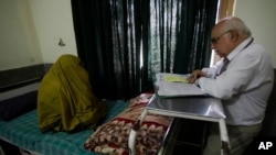 Pakistani psychiatrist Mian Iftikhar Hussain talks to a woman who suffers from severe depression after her cousin was killed by a mortar, at a local hospital in Peshawar, July 3, 2012.