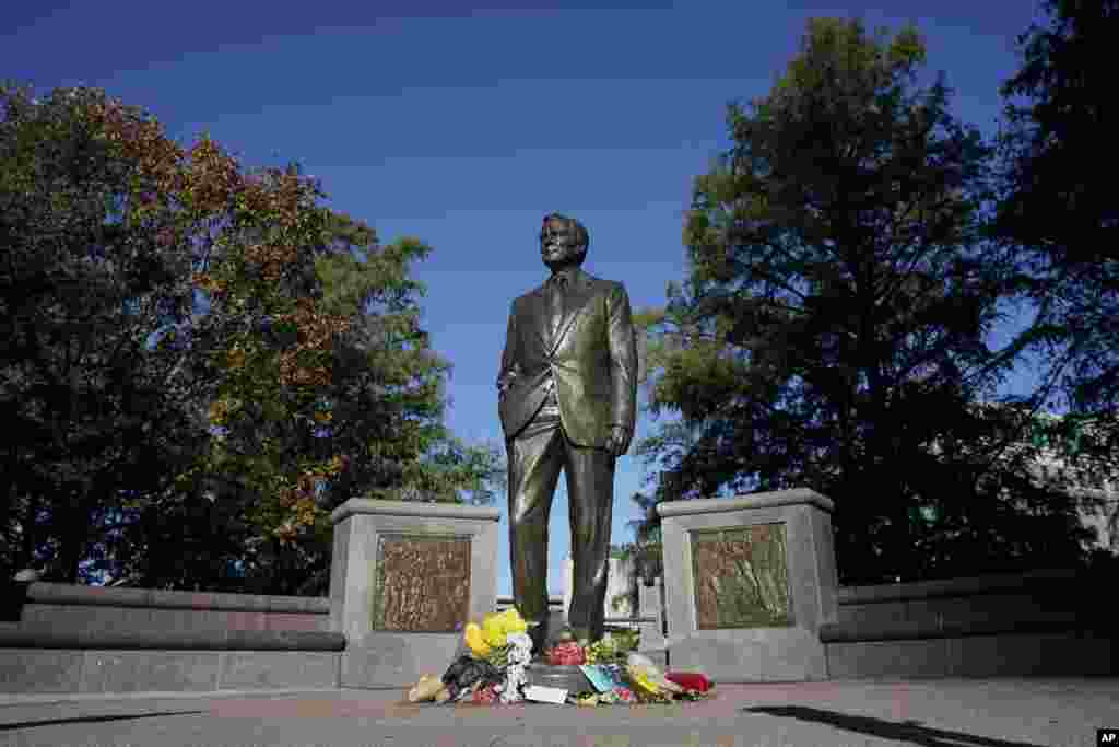 Временный мемориал у основания статуи бывшего президента Джорджа Буша-старшего в центре Хьюстона, Техас