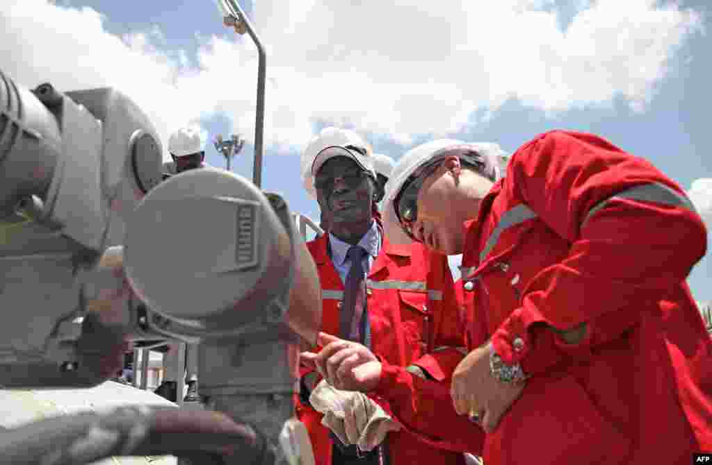 South Sudan's Minister for Petroleum and Mining Stephen Dhieu Dau (L) prepares to press button to resume oil production May 5, 2013, Paloch, South Sudan