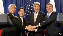 From left, Japanese Defense Minister Gen Nakatani, Japanese Foreign Minister Fumio Kishida, Secretary of State John Kerry, and Defense Secretary of Defense Ash Carter pose for a picture during a news conference in New York, Monday, April 27, 2015. The US and Japan are boosting their defense relationship, allowing Japan to play a bigger role in global military operations with an eye on potential threats from China and North Korea. (AP Photo/Seth Wenig))