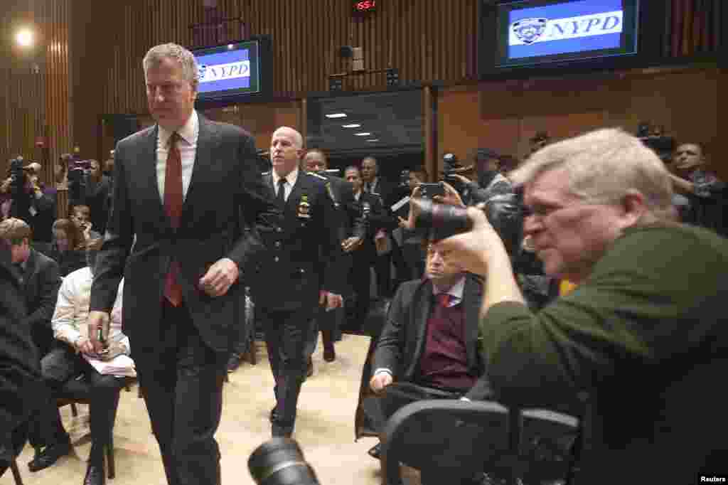 New York Mayor Bill de Blasio, left, arrives at the police headquarters for a news conference about the two NYPD police officers who were fatally shot in the Brooklyn borough of New York, Dec. 22, 2014.