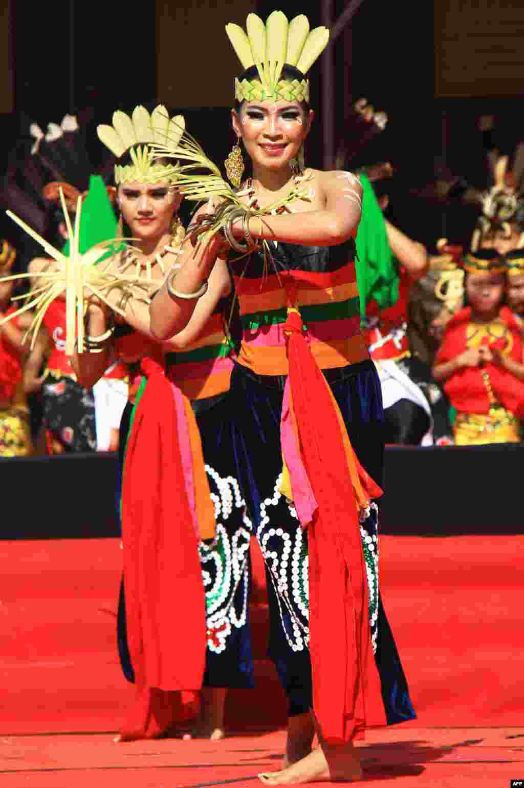 នារីរបាំសម្តែងក្បាច់រាំ Dayak នៅស្របពេលដែលទស្សនិកជនរង់ចាំមើលសូរ្យគ្រាសនៅក្រុង Palangkaraya ក្នុងកោះ Kalimantan ភាគកណ្តាល ប្រទេសឥណ្ឌូនេស៊ី។ 
