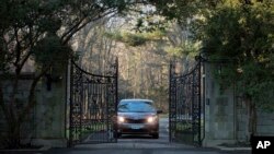 FILE - A car with diplomatic license plates drives out of a compound near Glen Cove, N.Y., on Long Island, Dec. 30, 2016. This is one of the compounds that former President Barack Obama ordered vacated in December.